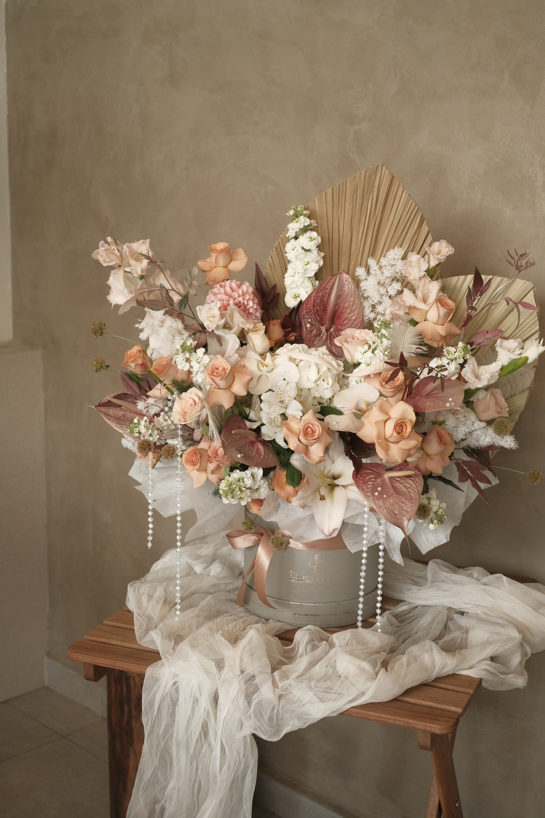 A stunning bloom box featuring a bold combination of brown and white flowers, accented by elegant cappuccino roses. This sophisticated arrangement showcases a unique blend of earthy tones and soft whites, creating a refined and modern floral display.