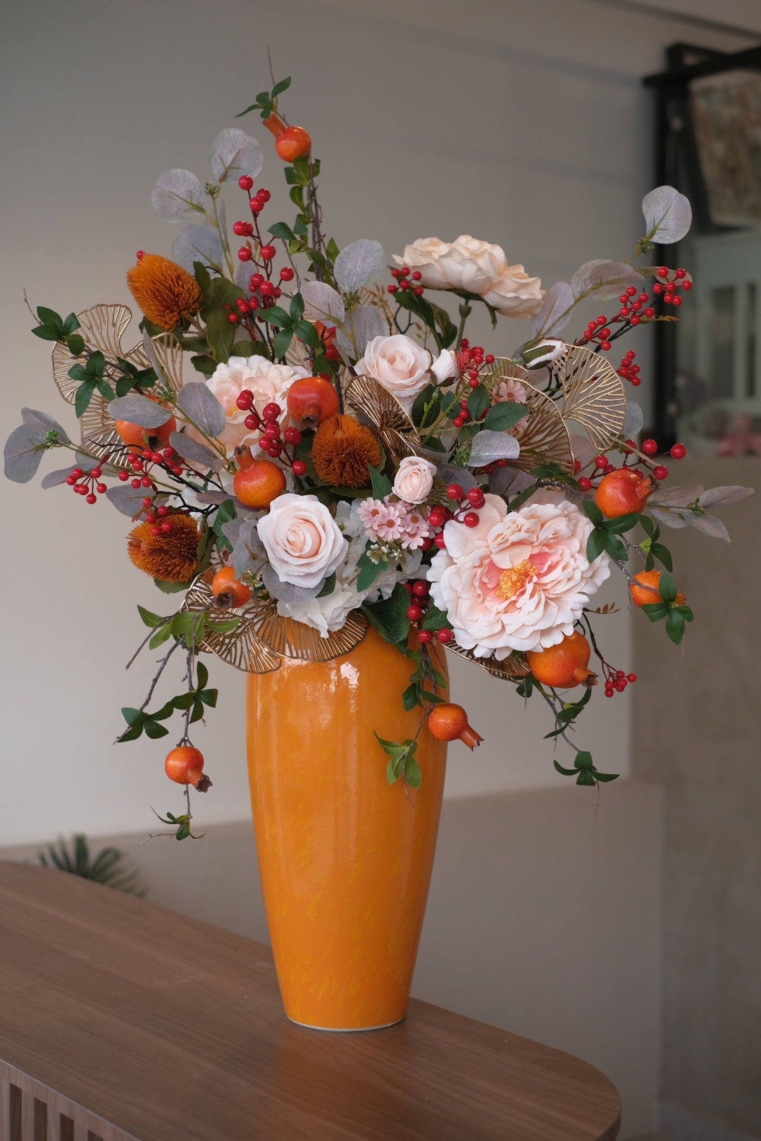 Adorned with luscious peach roses and delicate peonies, this arrangement brings a touch of elegance and warmth to your space. Housed in a vibrant orange ceramic pot, it not only symbolizes the bold energy but also serves as a stunning centerpiece to elevate your space for the auspicious event ahead.    Height: 72cm, Width: 53cm