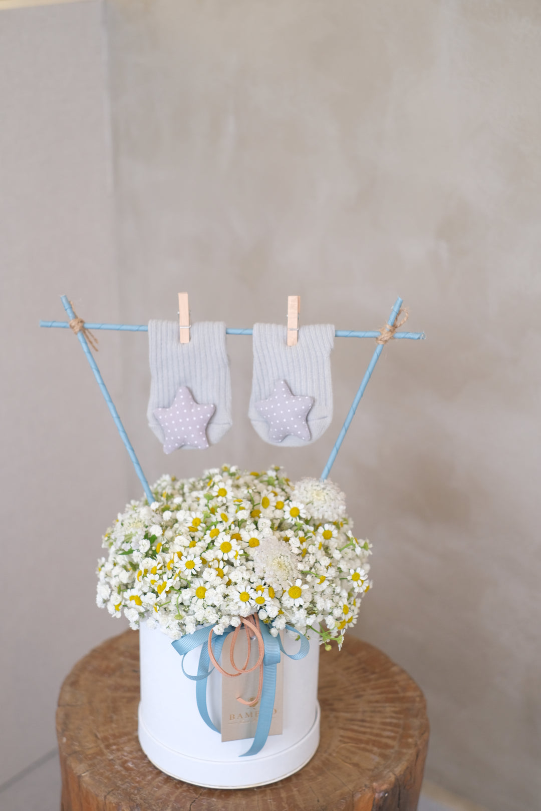 Blossoming into motherhood, one petal at a time. Chamomile, baby breath & socks, thoughtfully arranged for new moms. Same-day delivery by Penang Florist.