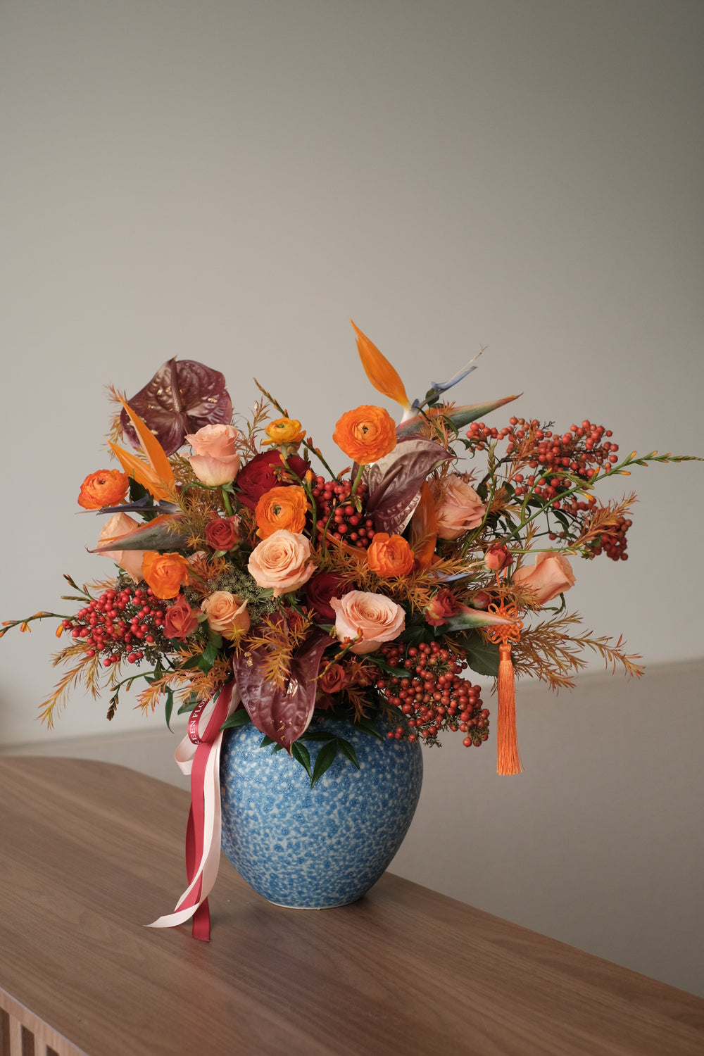 Omakase floral arrangement by Bamboo Florist, featuring vibrant orange blooms in a ceramic pot with Chinese design, inspired by Mandarin Oriental elegance. Designed to surprise and delight.