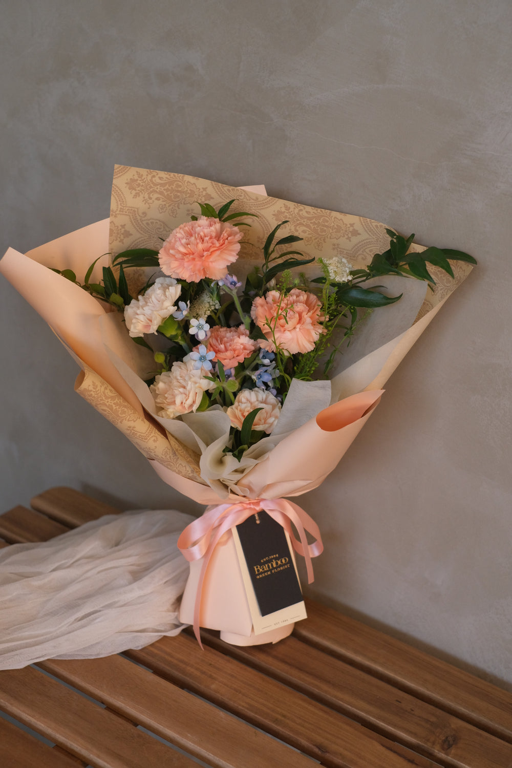 An elegant bouquet of assorted flowers, including carnations, roses, and lilies, arranged in a vase. The vibrant colors and delicate blooms convey love, gratitude, and appreciation for mothers and mother figures."