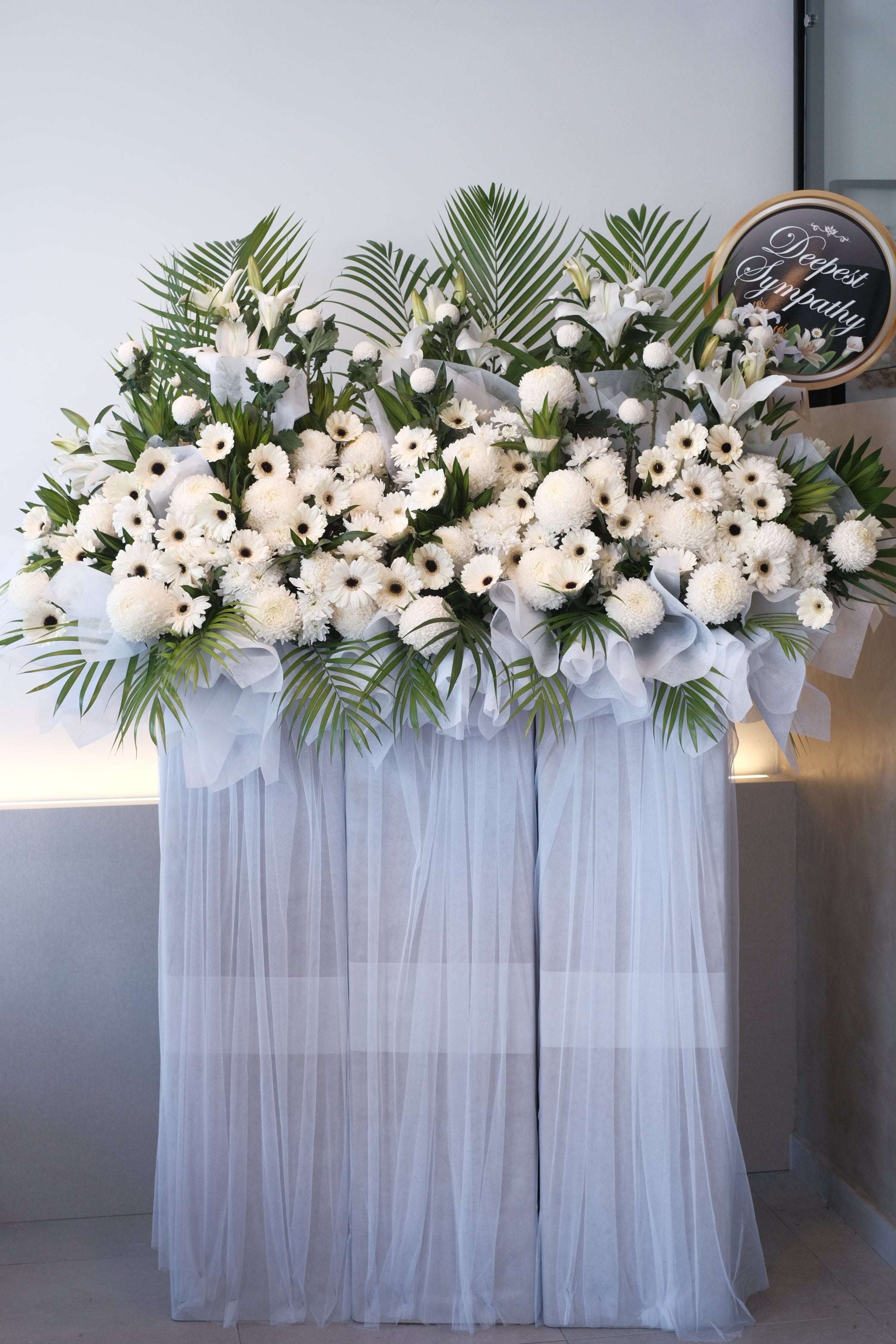 funeral stand flowers with white chrysanthemum, condolences message on wreath, in loving memory with white wrapping