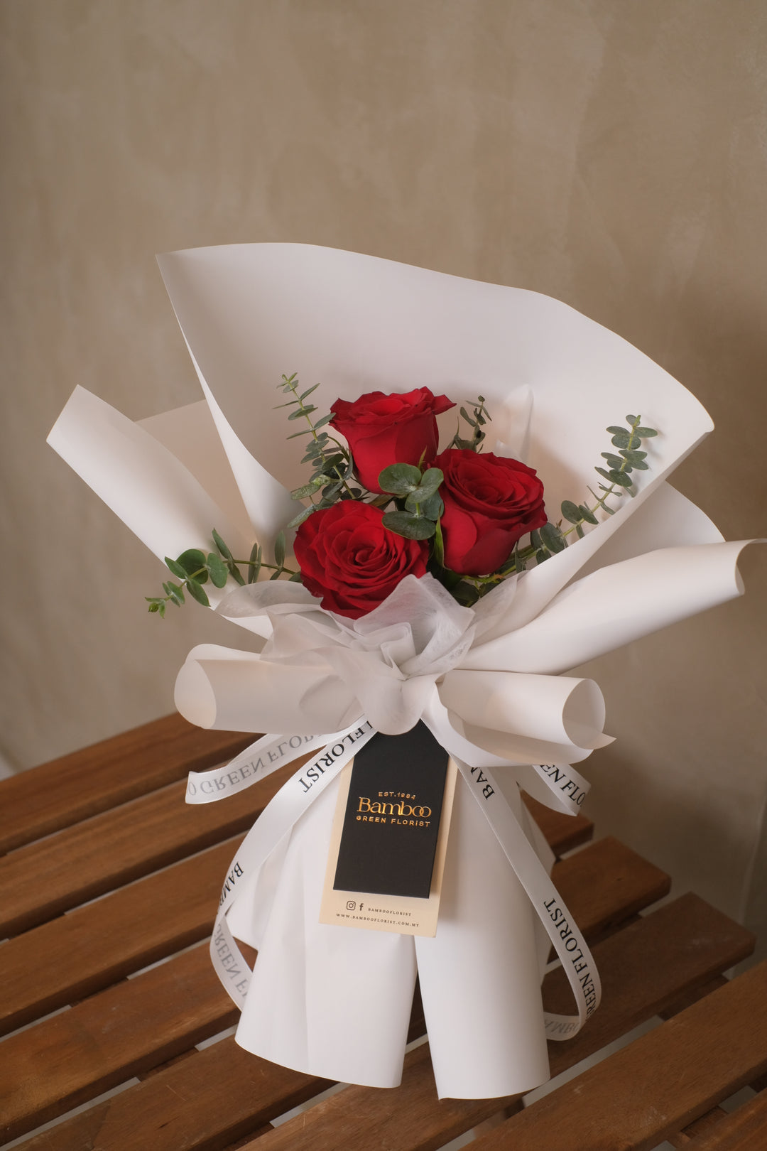 3 elegant red roses with fresh eucalyptus leaves, wrapped in white for a timeless touch. Order online from Bamboo Green Florist, a trusted Penang florist with delivery.