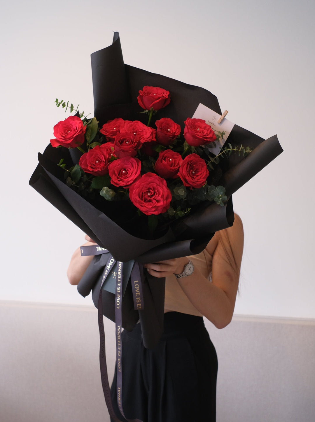 Classic red roses paired with eucalyptus leaves, elegantly wrapped in black for a timeless romantic gesture. Order from Bamboo Green Florist, Penang.