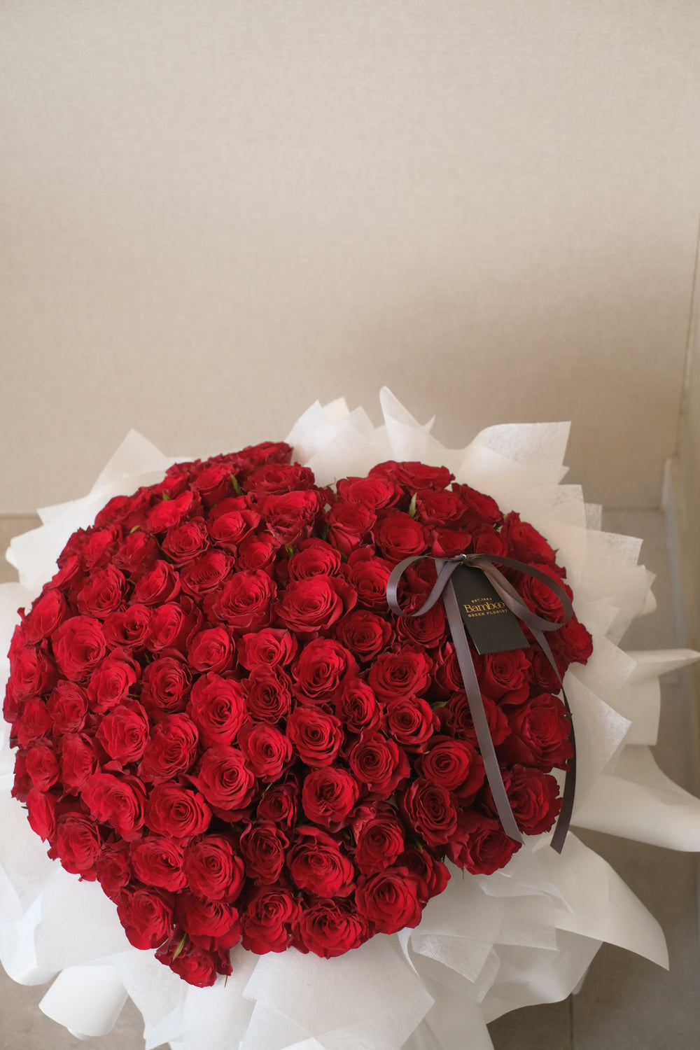 99 roses hand-tied into an elegant bouquet, symbolizing love and beauty. Premium floral arrangement, romantic roses, luxurious bouquet, Penang florist.