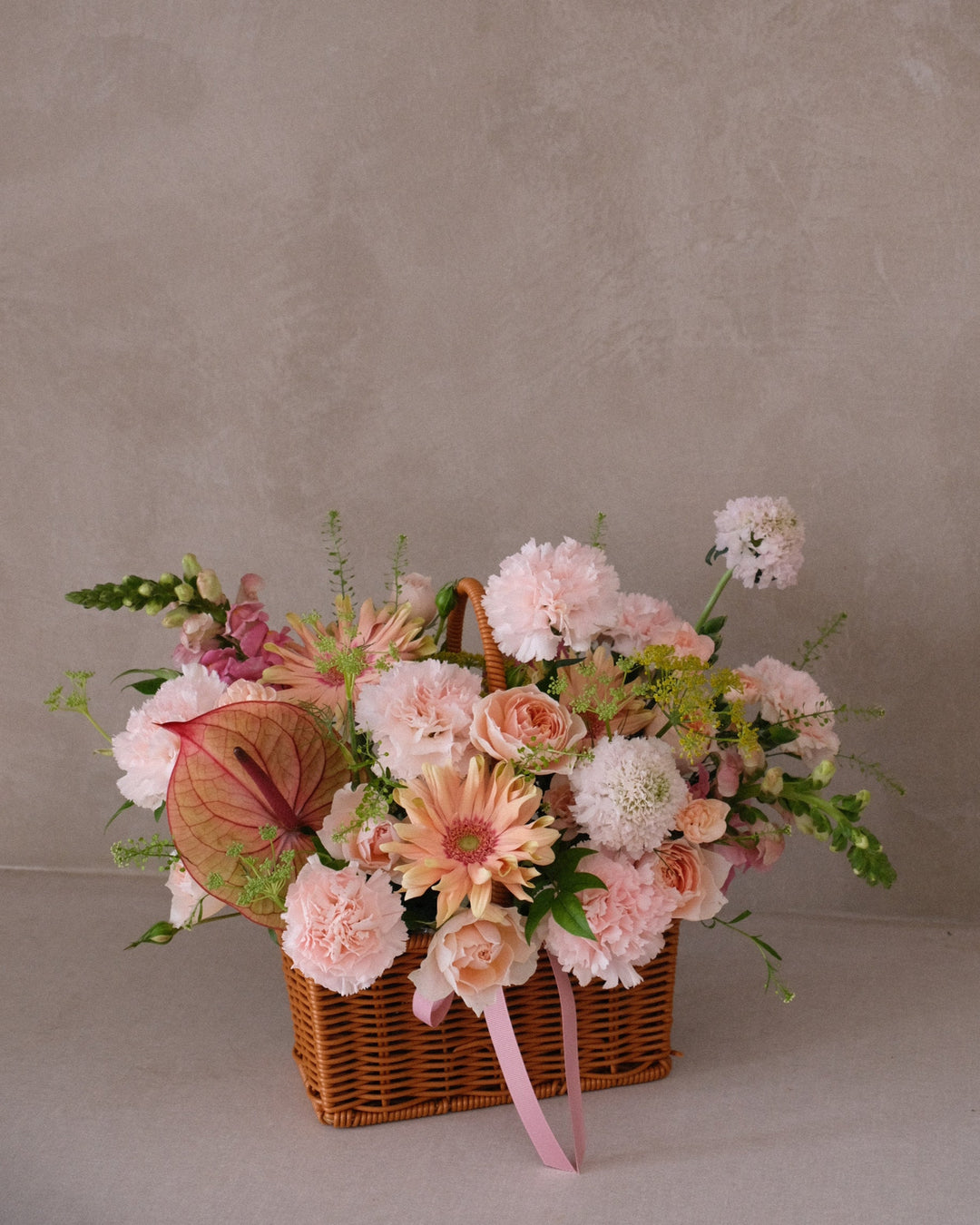 Pastel pink, apricot, and cream floral arrangement in woven garden basket for Mother’s Day – Savonade by Bamboo Green Florist, Penang