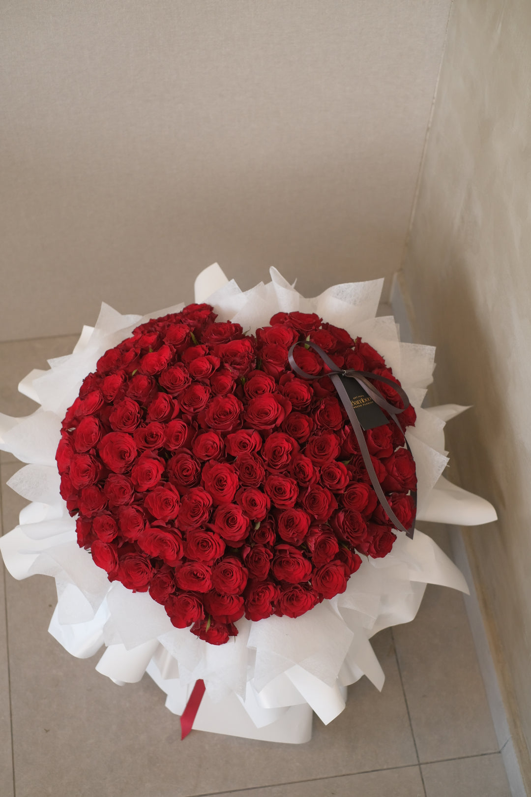 99 roses hand-tied into an elegant bouquet, symbolizing love and beauty. Premium floral arrangement, romantic roses, luxurious bouquet, Penang florist.
