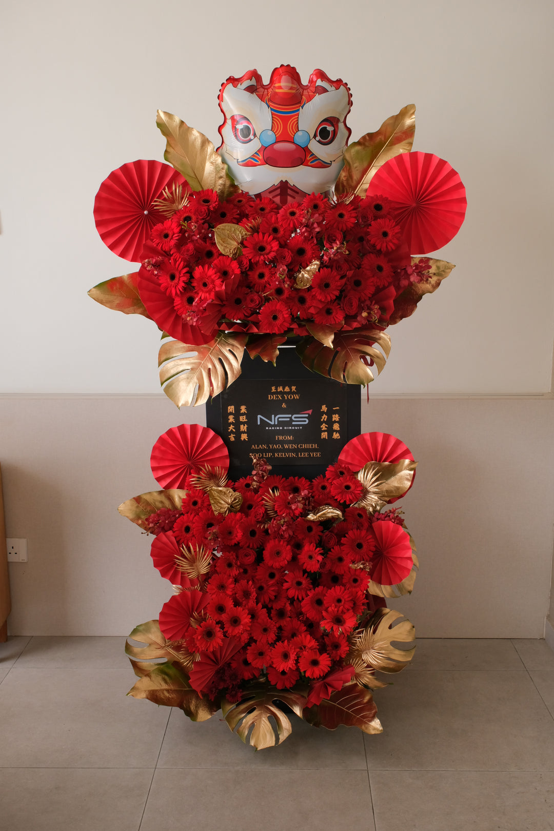 The Golden Lion grand opening flower stand — double-tier red gerberas, gold leaves & lion head design by Bamboo Green Florist Penang