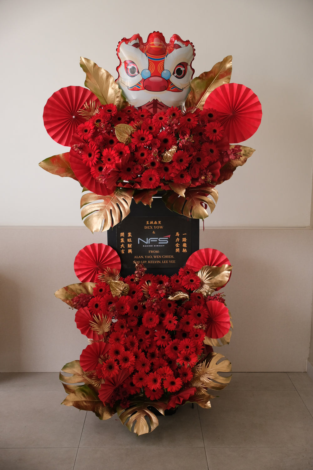 The Golden Lion grand opening flower stand — double-tier red gerberas, gold leaves & lion head design by Bamboo Green Florist Penang