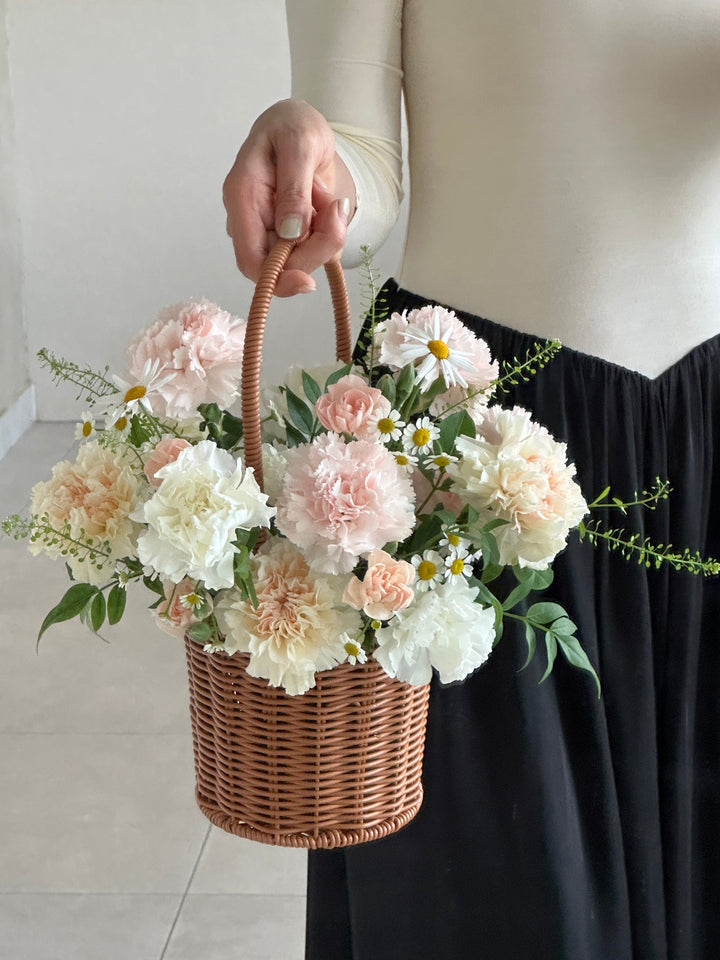 Mixed soft carnations in a handwoven basket