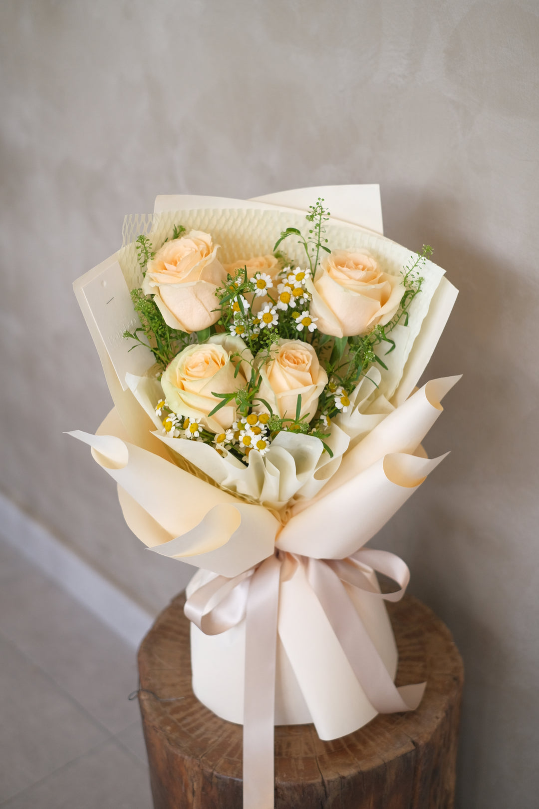 Blushing shades of champagne roses, exuding elegance and timeless charm in a beautifully curated arrangement.