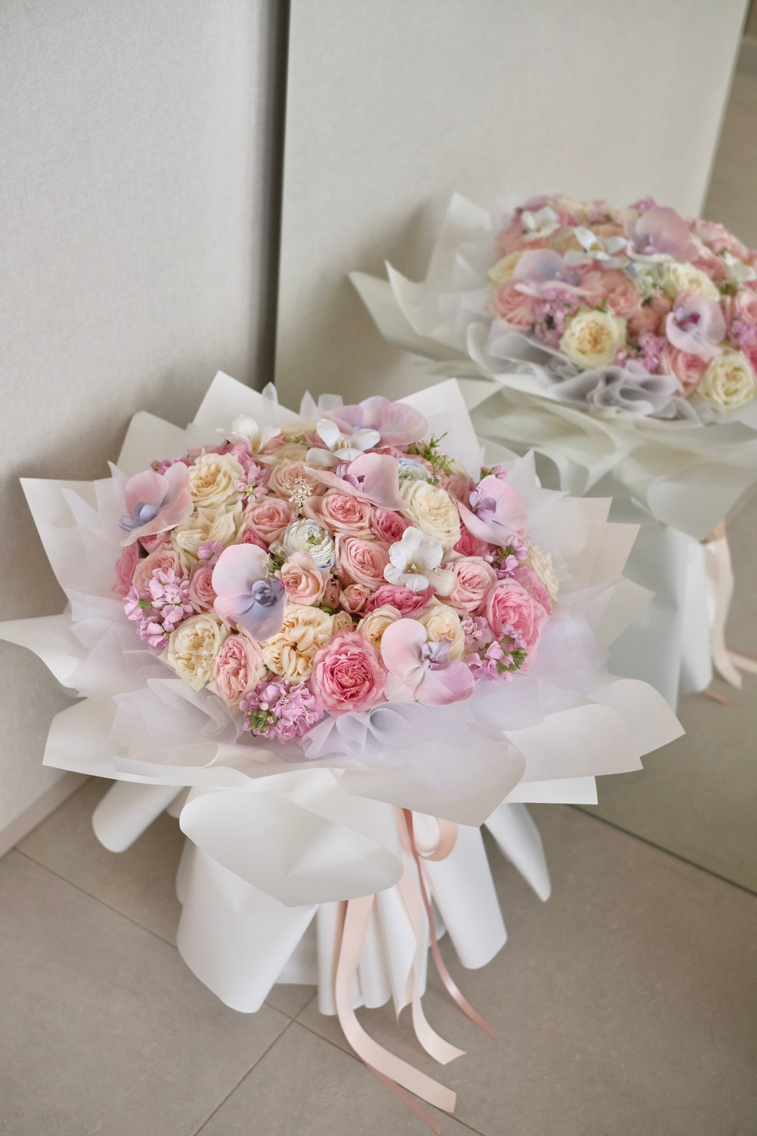 Elegant mixed bouquet featuring roses and Phalaenopsis orchids in white, pink, and blue varieties. Order online from Bamboo Green Florist, your trusted Penang florist with delivery.