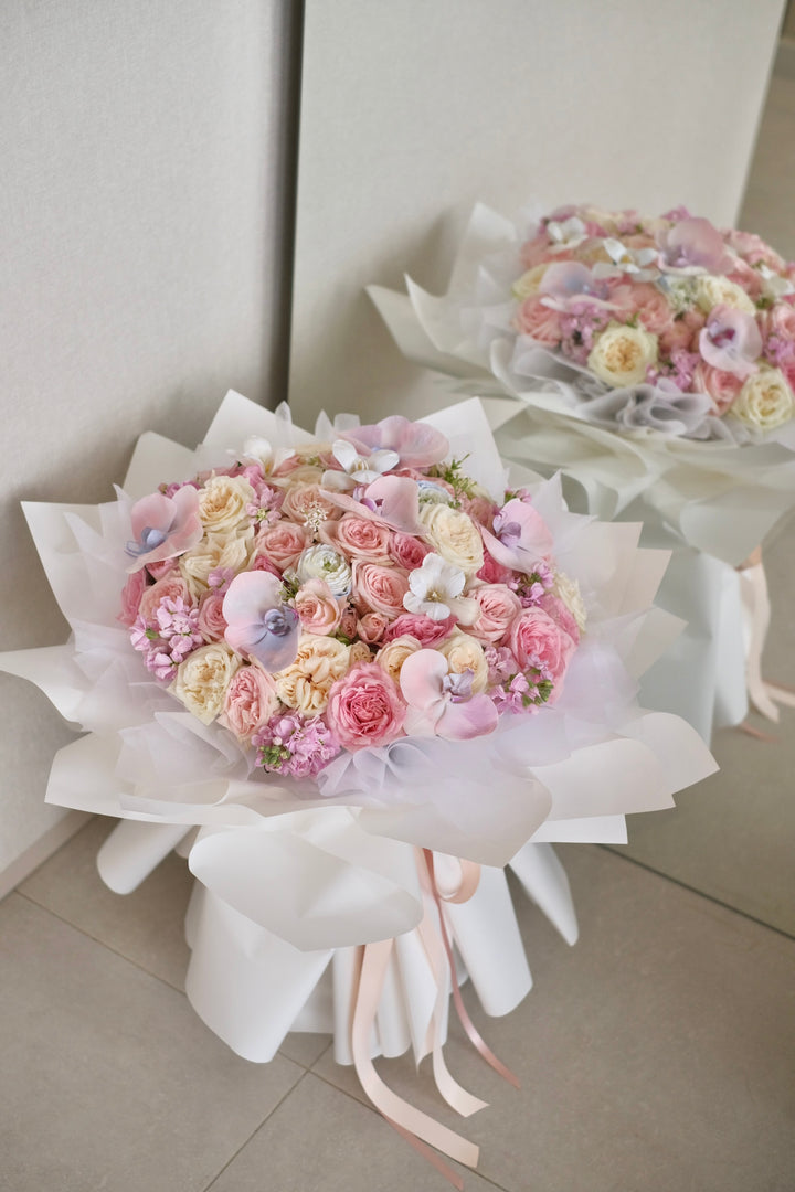 Elegant mixed bouquet featuring roses and Phalaenopsis orchids in white, pink, and blue varieties. Order online from Bamboo Green Florist, your trusted Penang florist with delivery.
