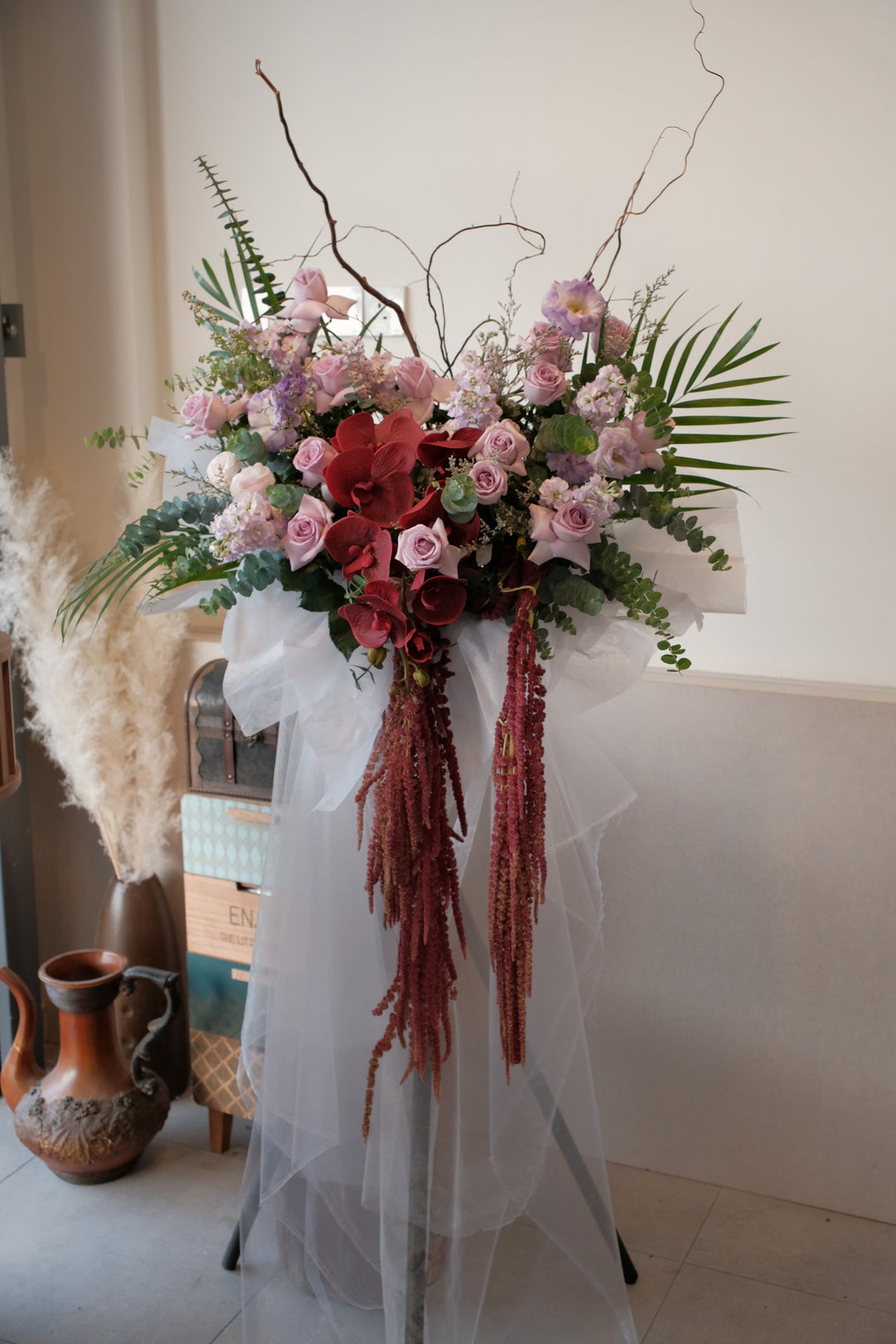 Bold purple grand opening flower stand with cascading red amaranthus and artificial red orchid, by Bamboo Green Florist Penang.
