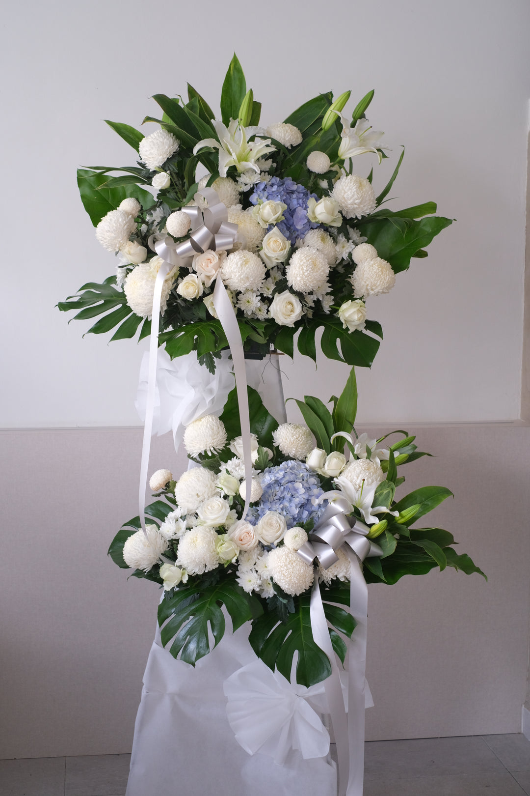 Same-day condolences flowers delivery in Penang - A serene arrangement of white hydrangeas, gerberas, roses, fillers, and greens, expressing love and remembrance during a difficult time."