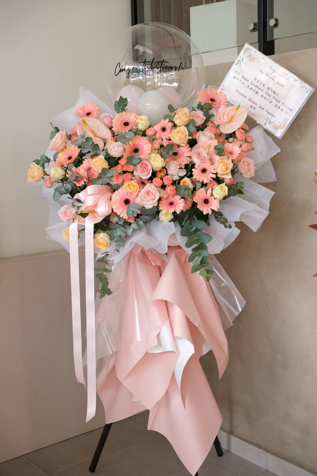 Grand opening flower stand with pink and champagne blooms, balloons, and personalised printed message by Bamboo Green Florist Penang
