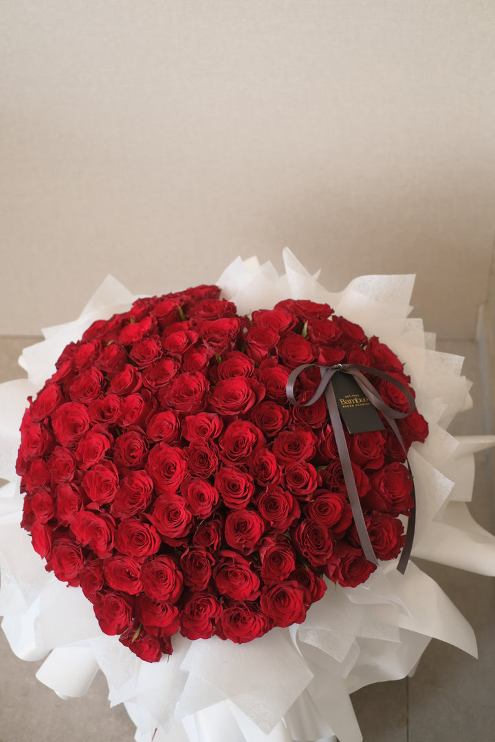 99 roses hand-tied into an elegant bouquet, symbolizing love and beauty. Premium floral arrangement, romantic roses, luxurious bouquet, Penang florist.