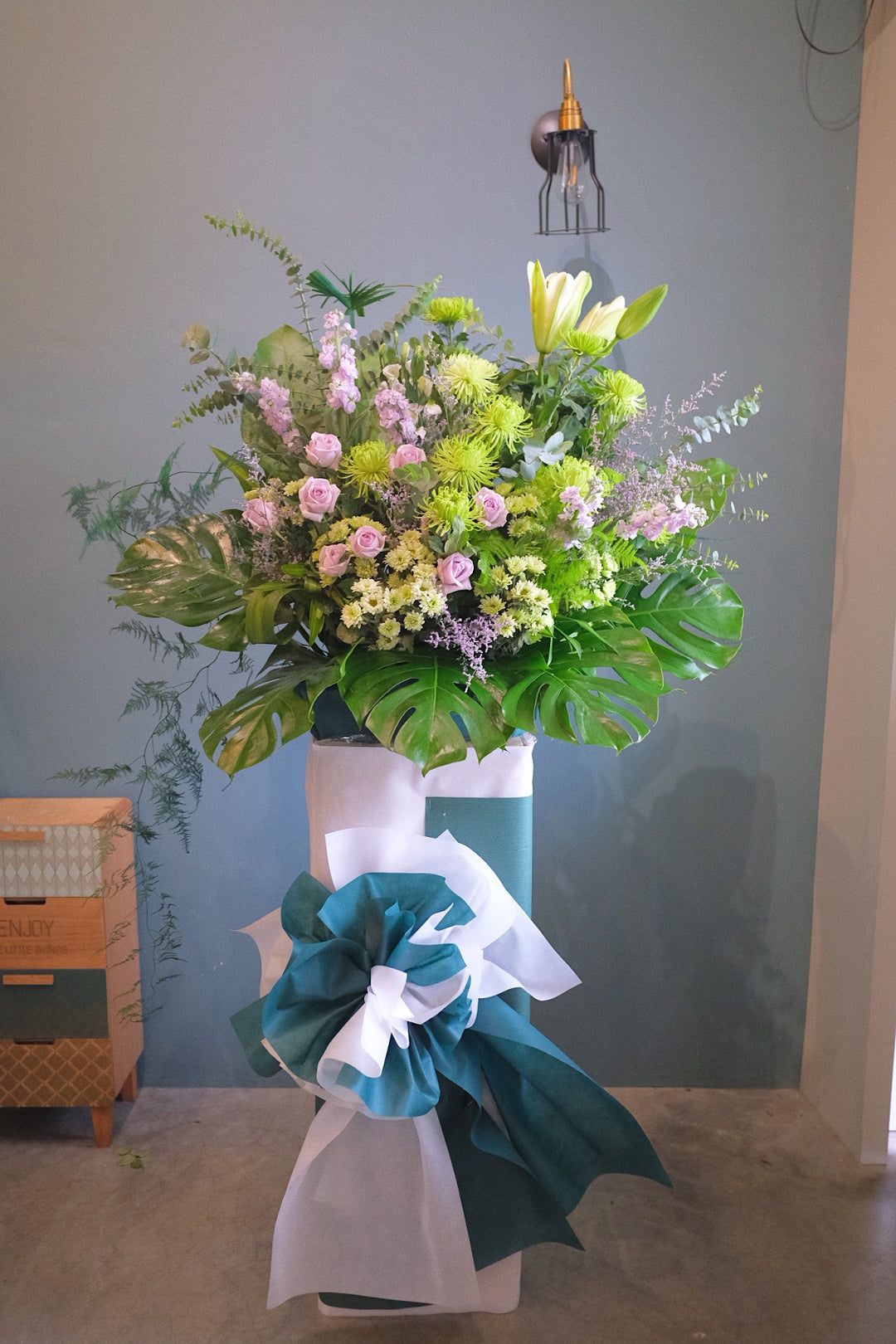 This beautiful, lilac flowers and soothing greens creates a peaceful presentation at any funeral or wake. The classic wreath is delivered on a box stand, and is a gracious expression of sympathy and appreciation. For same day condolences flowers delivery in Penang.