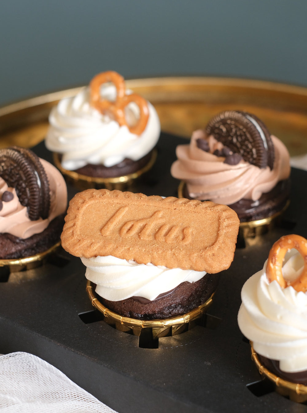 Chocolate cupcakes topped with Lotus biscuits, Oreo, & pretzels by Bamboo Green Florist – a delightful treat in Penang. Order now for delivery!
