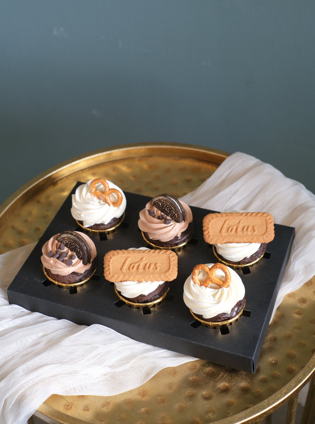 Chocolate cupcakes topped with Lotus biscuits, Oreo, & pretzels by Bamboo Green Florist – a delightful treat in Penang. Order now for delivery!