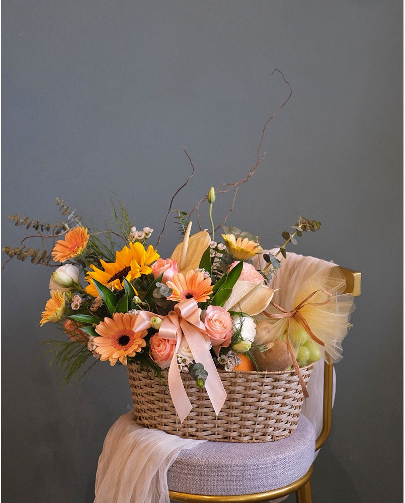 Here's the bright colour of flower arrangement in a willow basket and a variety of imported fruits to cheer someone up. Same day fruit basket delivery in Penang and Butterworth.