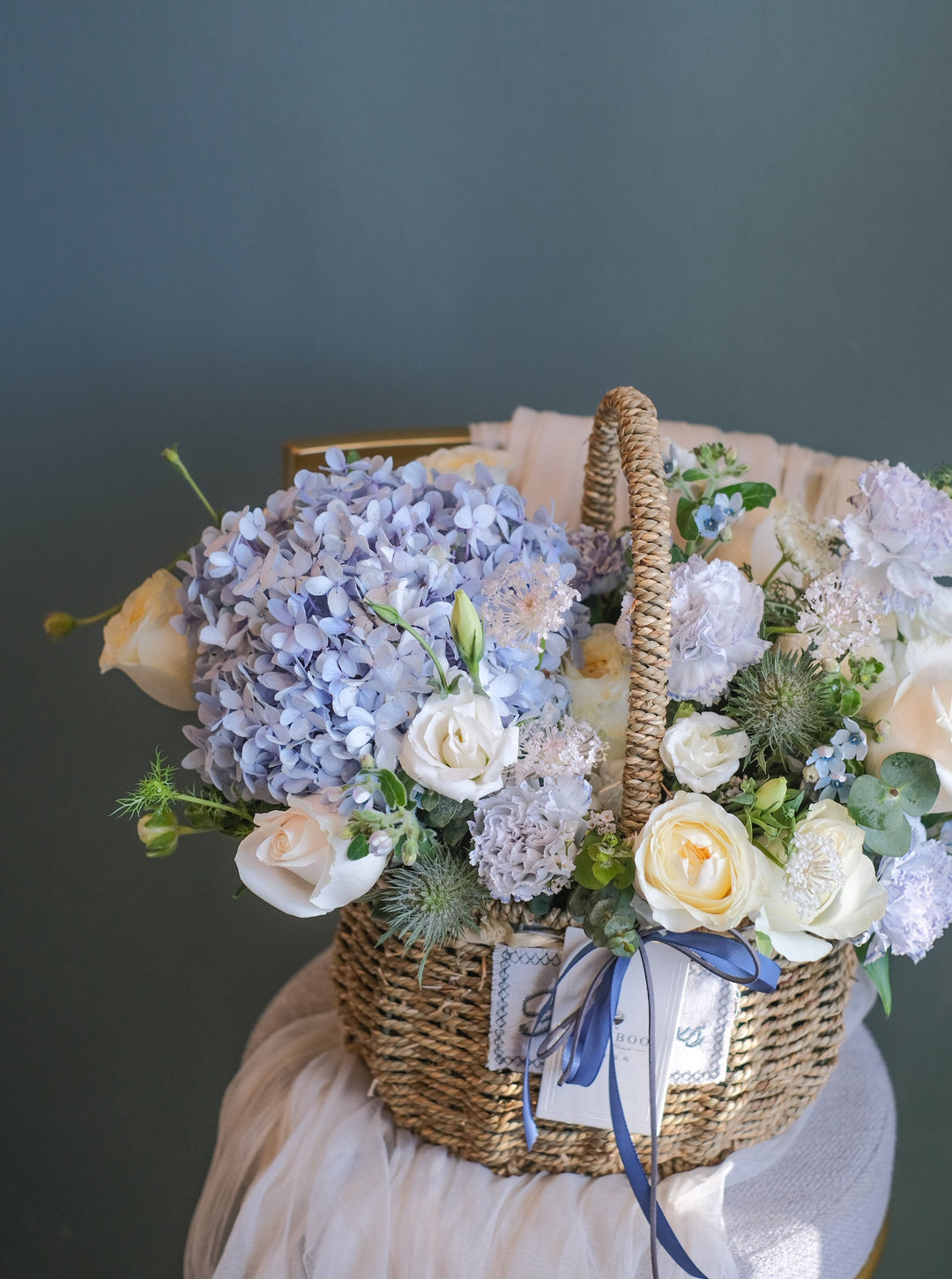 Elegant blue, cream & white flower arrangement featuring hydrangeas, roses, carnations & eustomas. Perfect for any celebration. Same-day delivery in Penang!