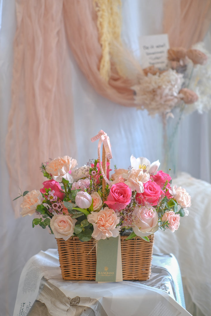 Warm and blushing flower basket with carnations, hot pink roses, tulips, and lush leaves. Perfect Mother’s Day gift. Same-day delivery in Penang & Butterworth.