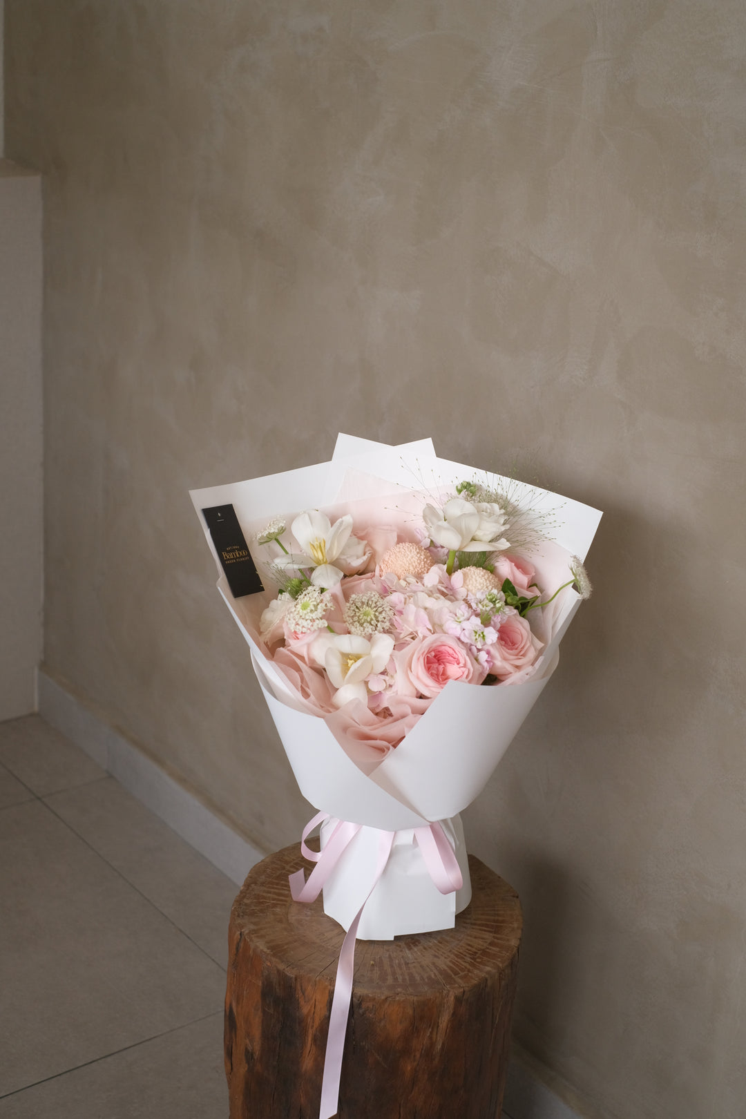 This breathtaking floral arrangement features radiant pink roses, delicate hydrangeas, and exquisite tulips, creating a dazzling display of freshness and joy. The soft, romantic hues of the pink roses exude warmth and cheer, perfect for her !