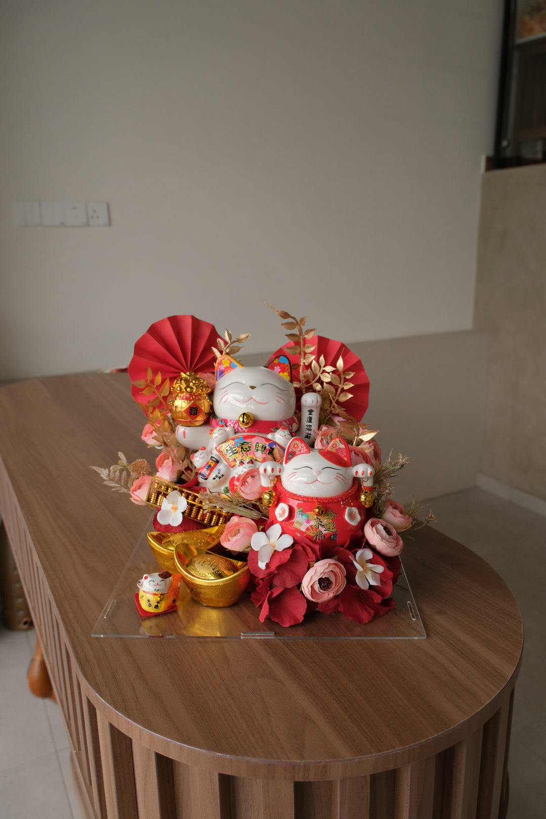 Clear acrylic box with 3 Maneki-neko Lucky Cats, 2 gold knots, golden abacus, and artificial flowers – Prosperity gift from Bamboo Green Florist

