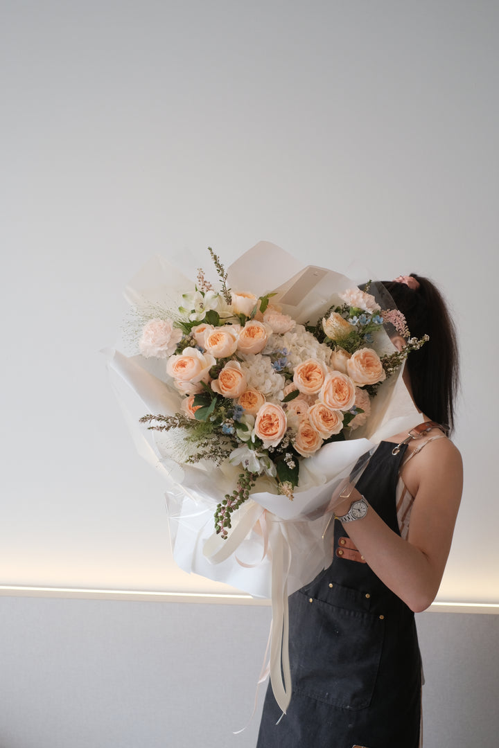 A bouquet of luxurious, high-quality Juliet roses with vibrant and luscious petals in various shades of pink and peach