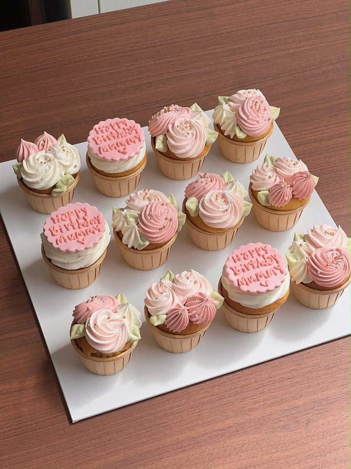 Set of twelve hand-piped pink and cream rose cupcakes with gold pearls and a personalised birthday message, by Bamboo Green Florist, best florist in town