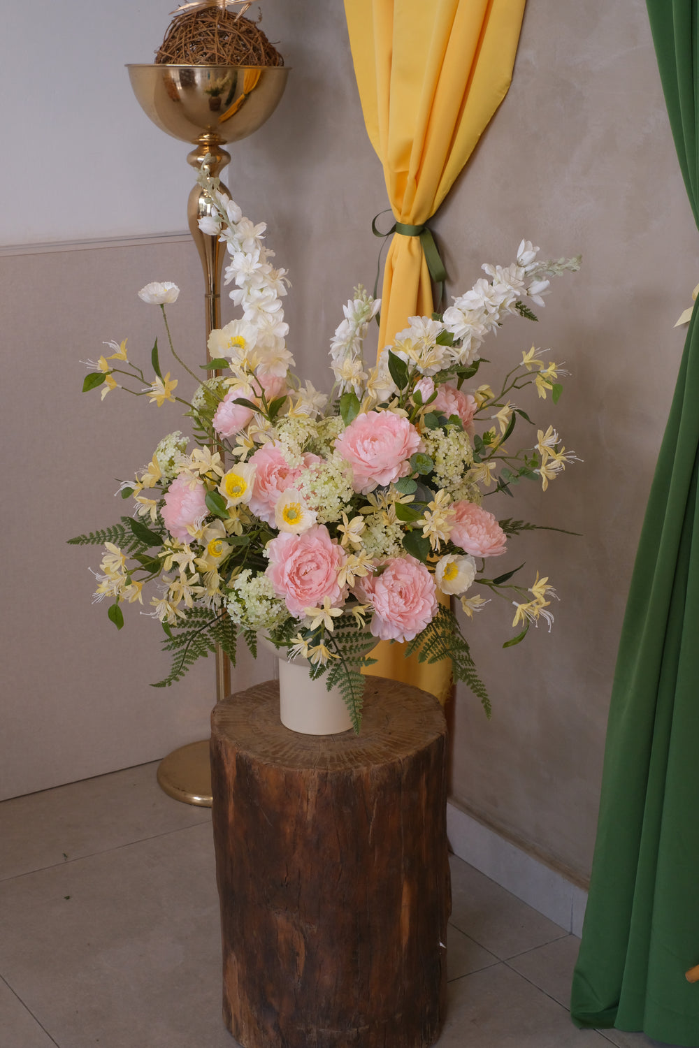 Kirana artificial flower arrangement with tall white delphiniums, pastel pink roses, and soft yellow wild flowers in a matte black vase for modern Raya decor.