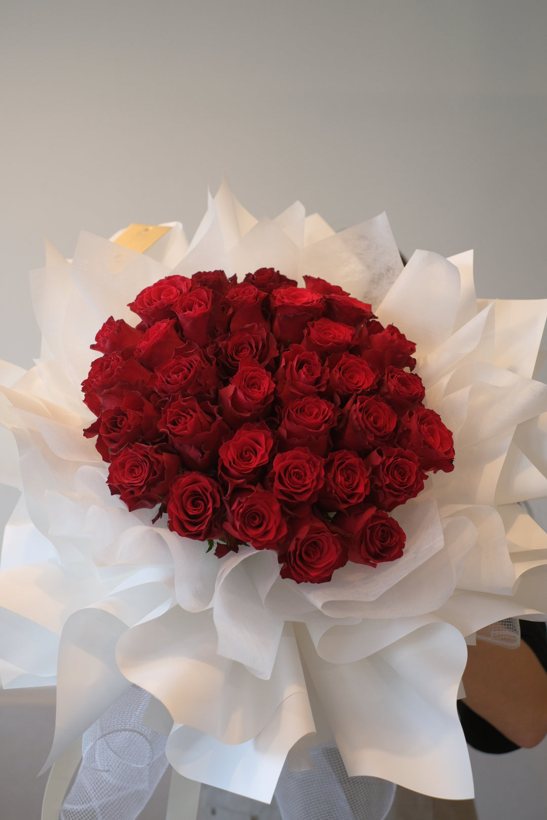 "Image of stunning red roses elegantly presented in white wraps, ideal for creating a showstopping display for your special occasions."