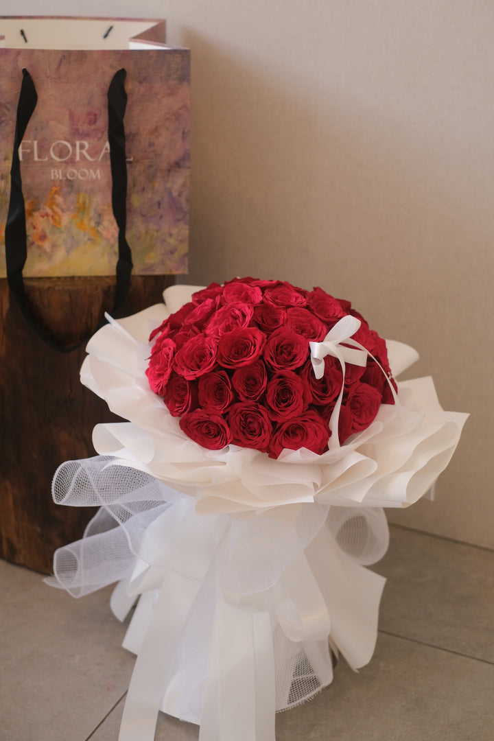 "Image of stunning red roses elegantly presented in white wraps, ideal for creating a showstopping display for your special occasions."