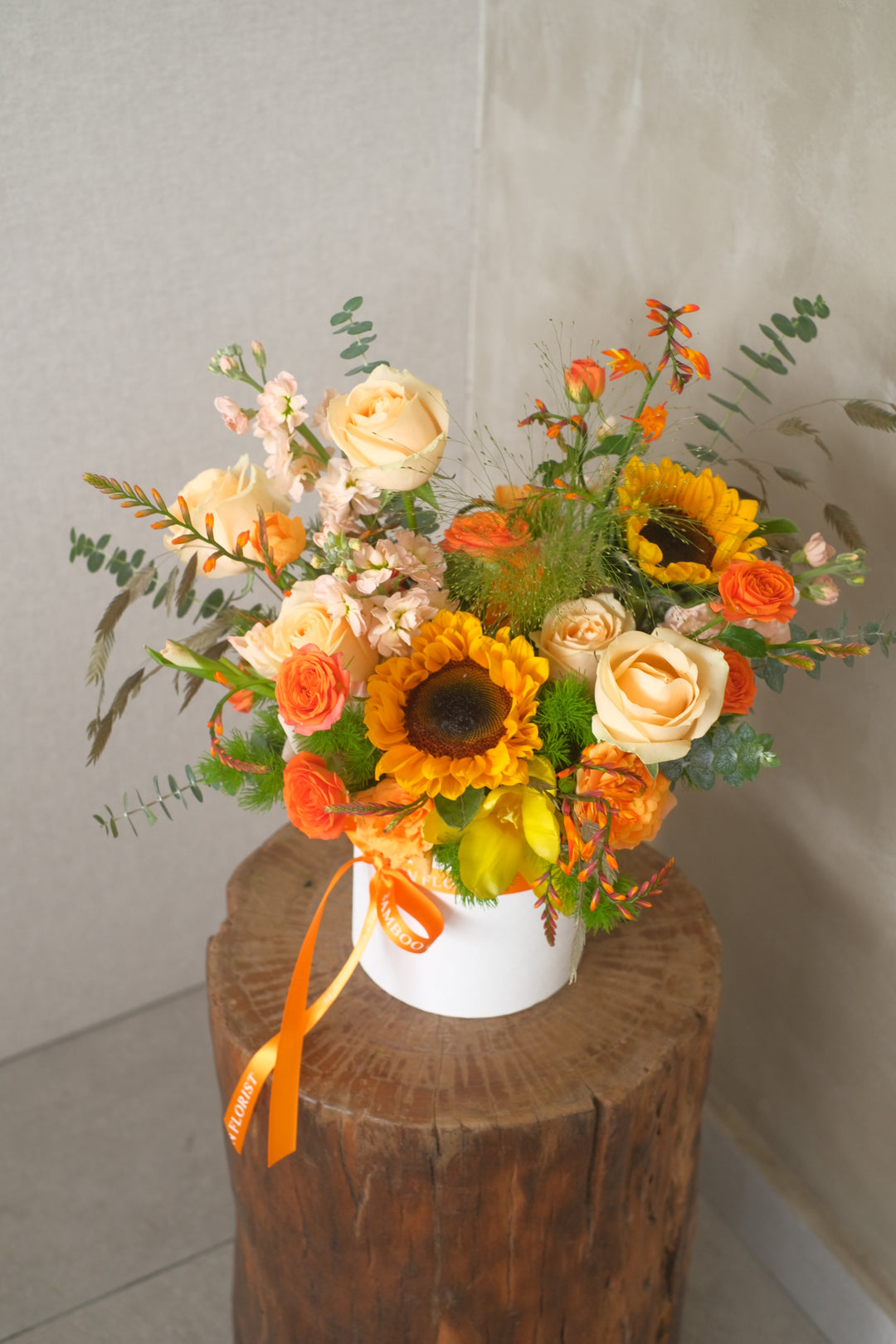 orange roses and sunflowers in a bloom box for delivery in penang