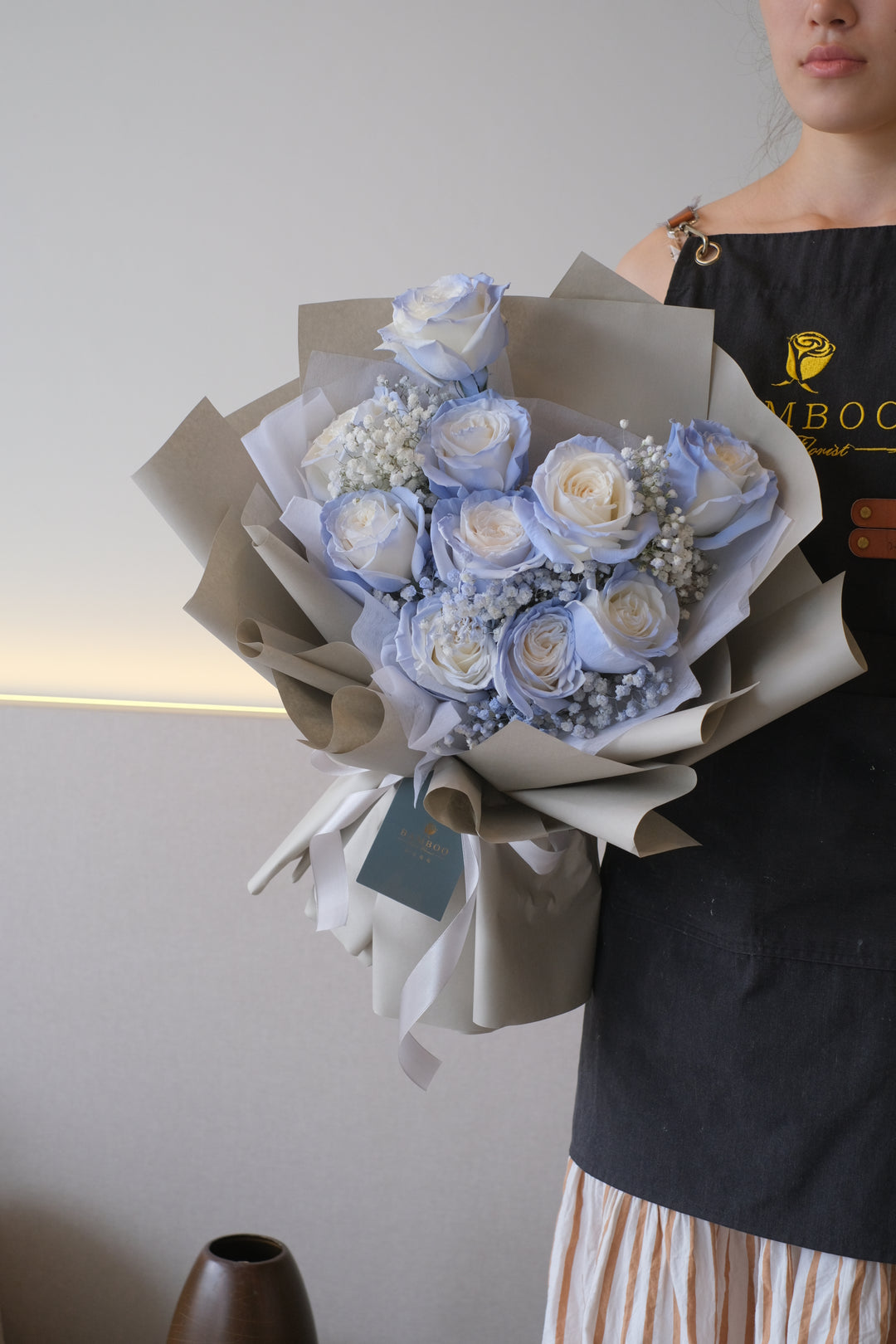 Image of a captivating bouquet featuring vibrant blue roses paired with delicate clusters of baby's breath, creating an enchanting and unique floral arrangement