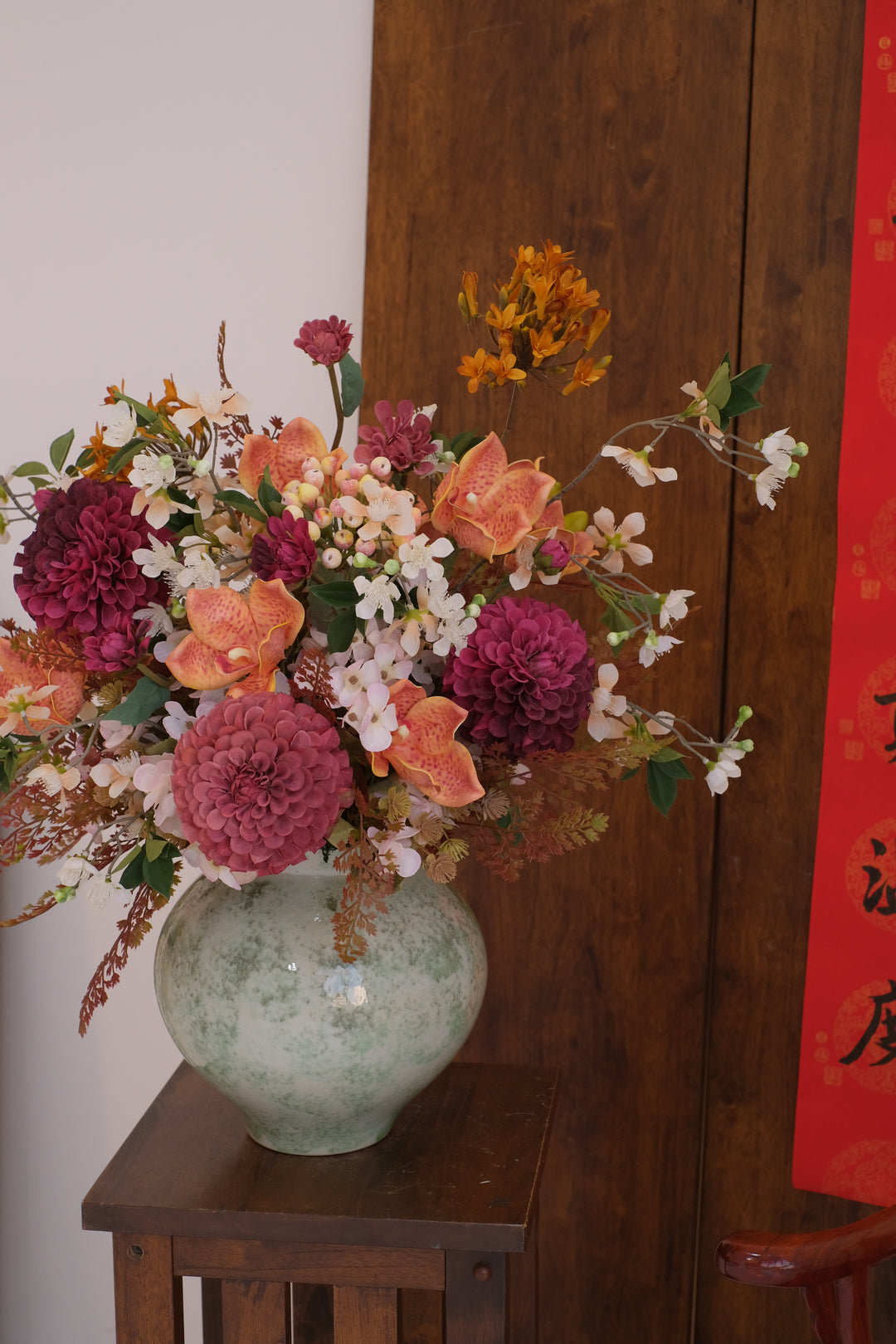Colorful floral arrangement on a wooden surface with a red banner in the background, by penang florist