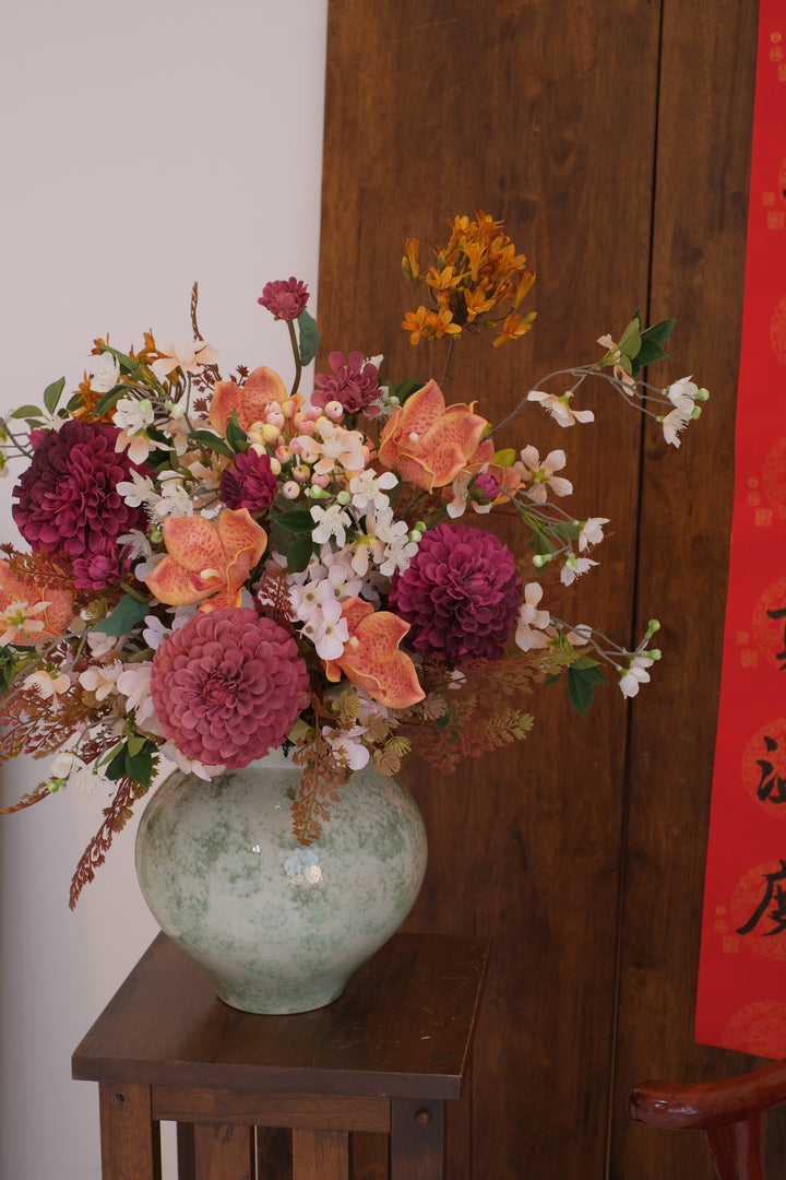 Colorful floral arrangement on a wooden surface with a red banner in the background, by penang florist