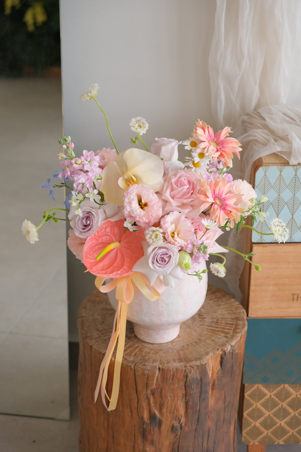 Close-up of coral anthurium, cream phalaenopsis and pale pink lisianthus, Sherbet Sky arrangement