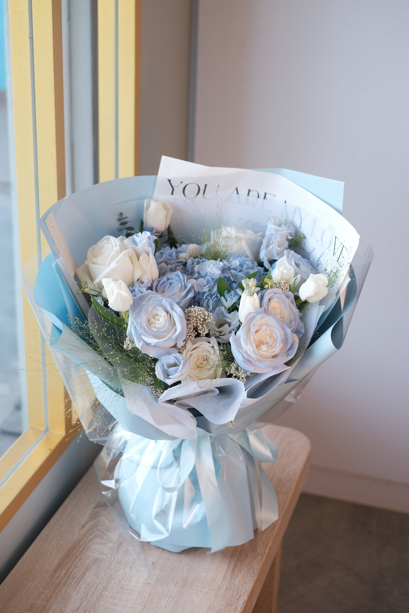 pastel coloured flowers complemented with a sea of blue perfection featuring hydrangeas, roses, eustomas, tulips, and assorted fillers.