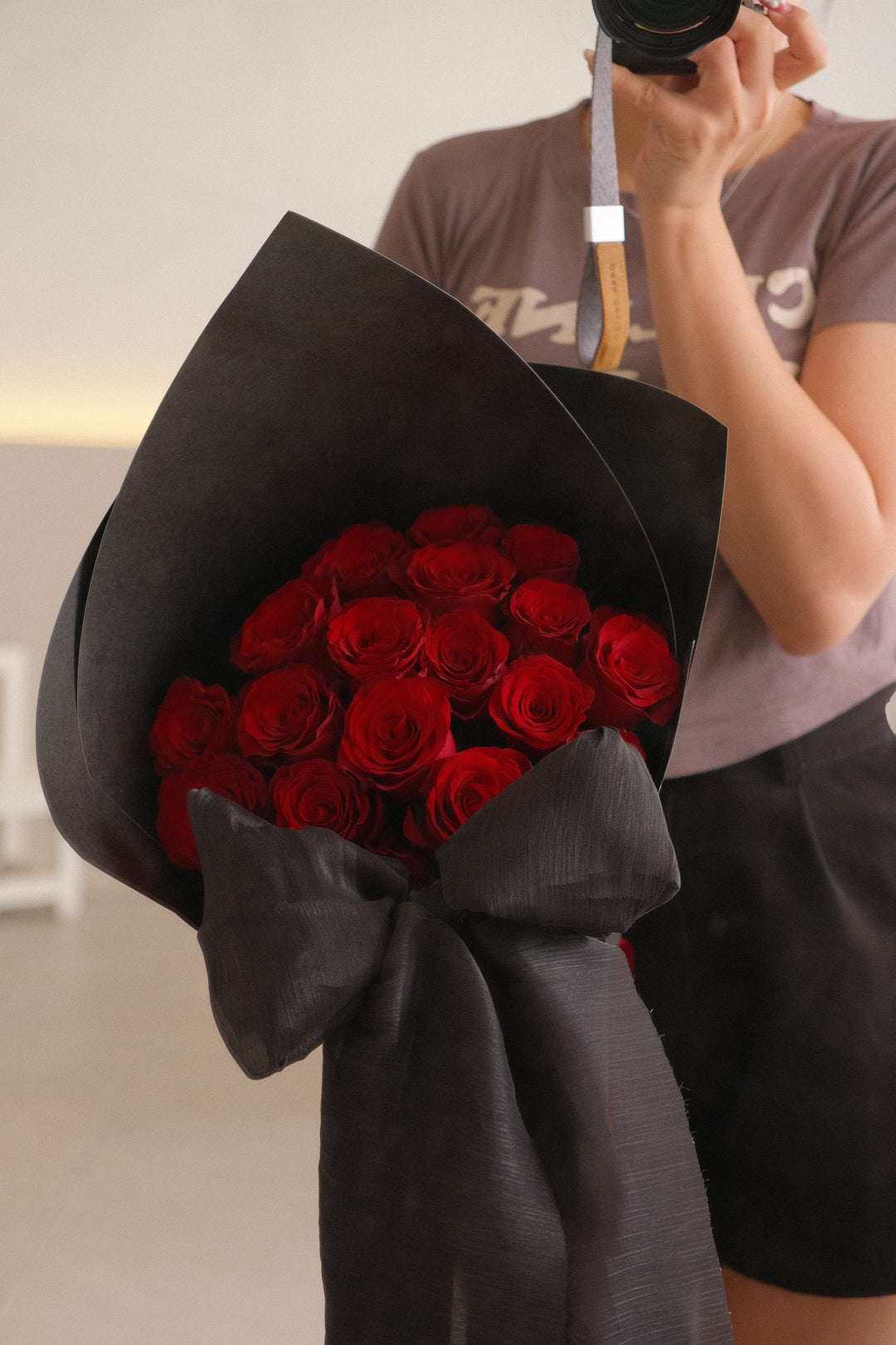 Sculpted bouquet of 20 red roses wrapped in hard paper with large black chiffon bow – bold and romantic flower arrangement by Bamboo Florist