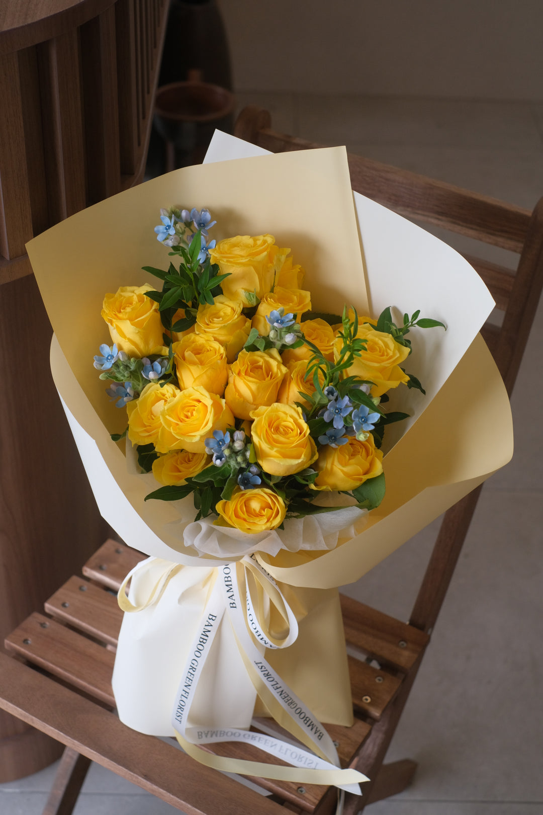 a delicate floral arrangement featuring a serene palette of soft white tones, beautifully accented with vibrant yellow roses.