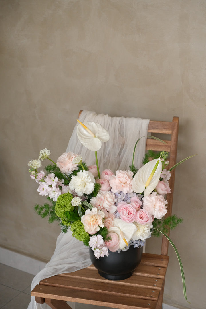 Architectural floral arrangement of white anthurium, blush roses and carnations in matte black sculptural vessel — best florist in town Penang Mother's Day floral arrangement RM358


