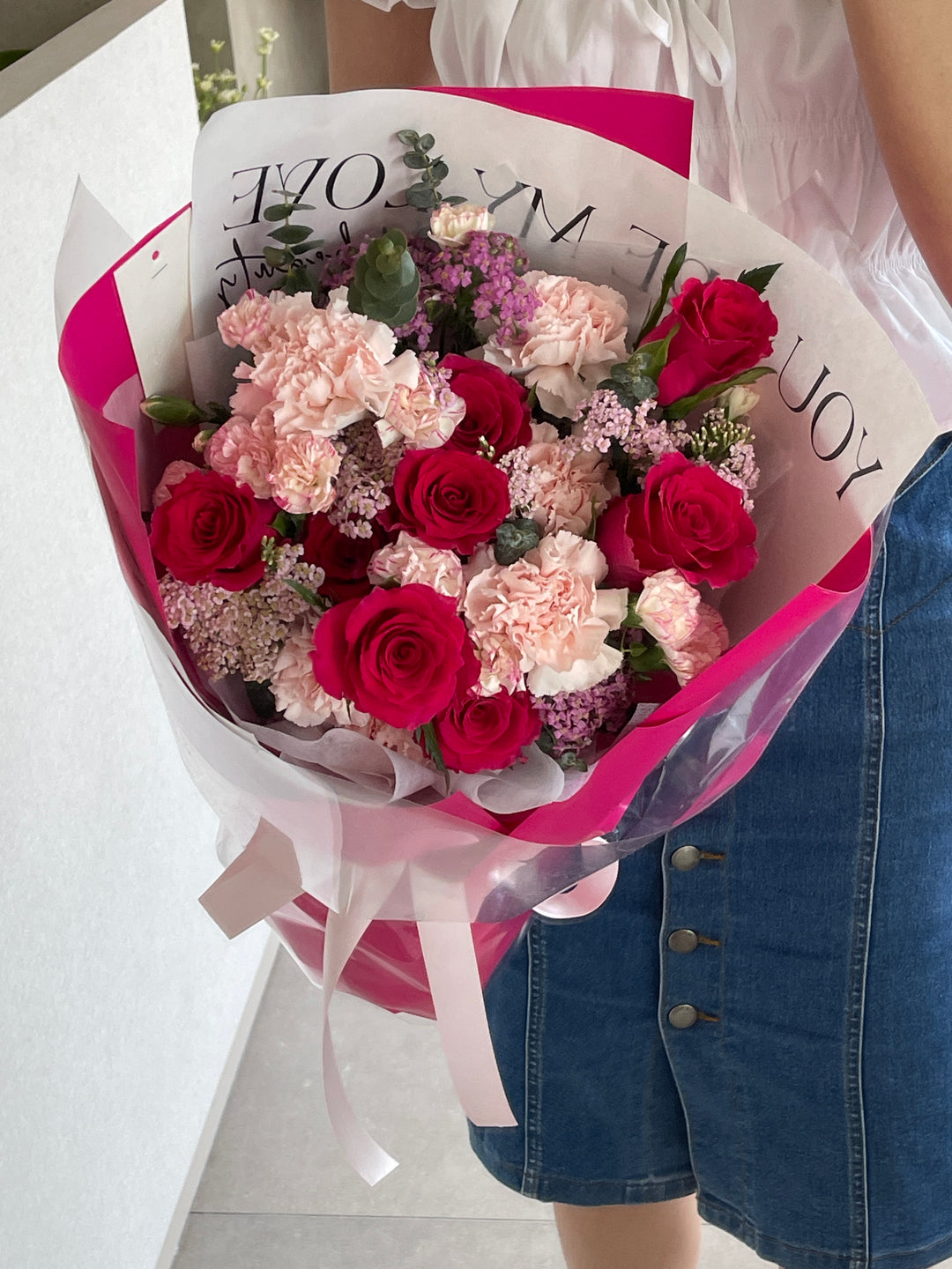 bouquet of roses with a combination of red, pink, and purple flowers