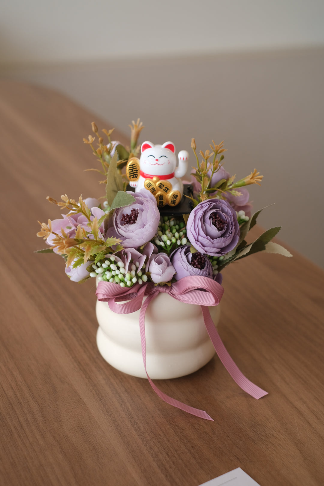 An exclusive mini Lucky cats designs, also known as Maneki-neko, are believed to bring good luck and prosperity. Combining them with artificial flowers symbolizes a wish for success and positive outcomes in the new venture.