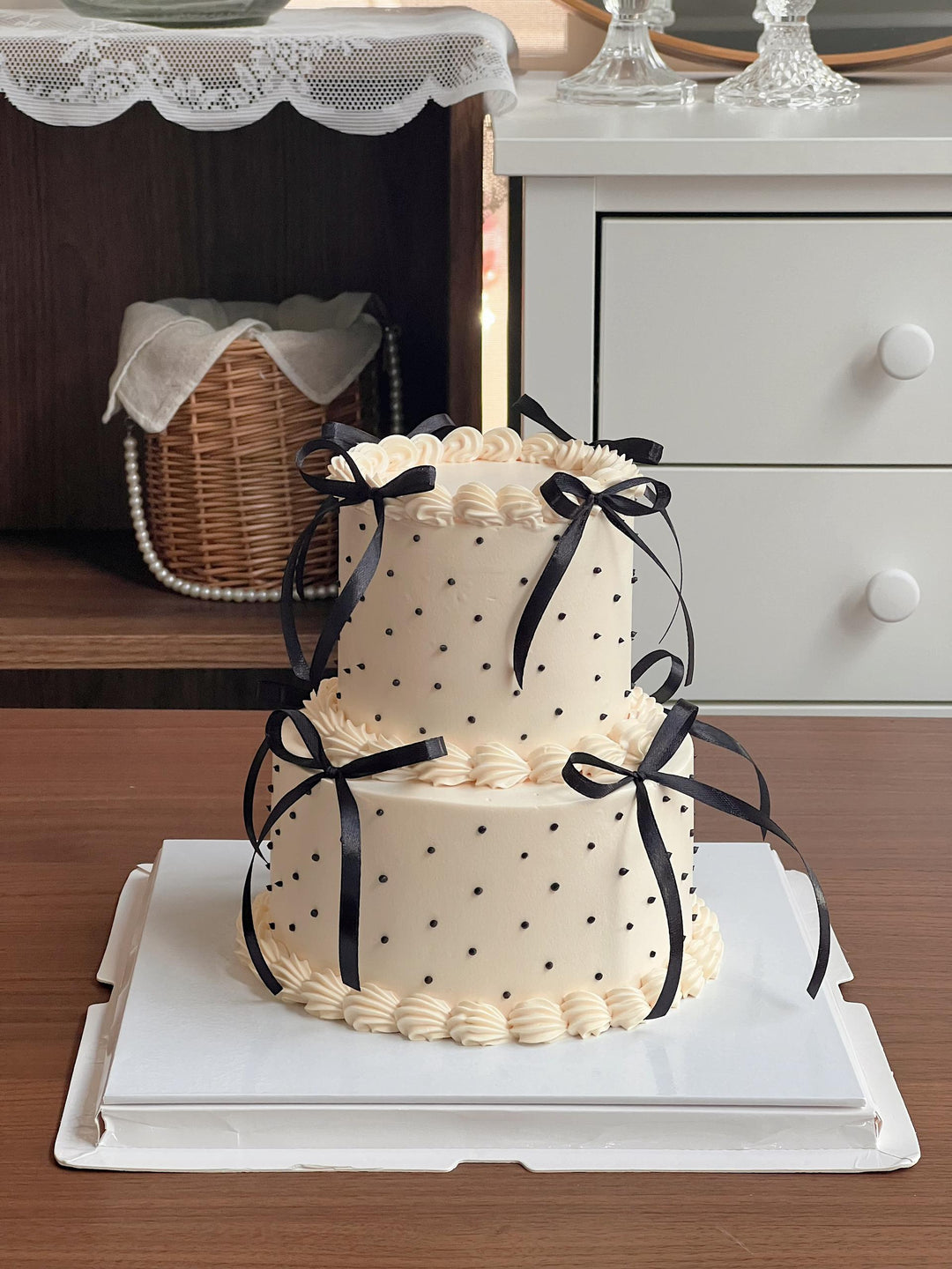 Moist cake with fresh cream finish and black bows on a white cake board, best florist in Penang