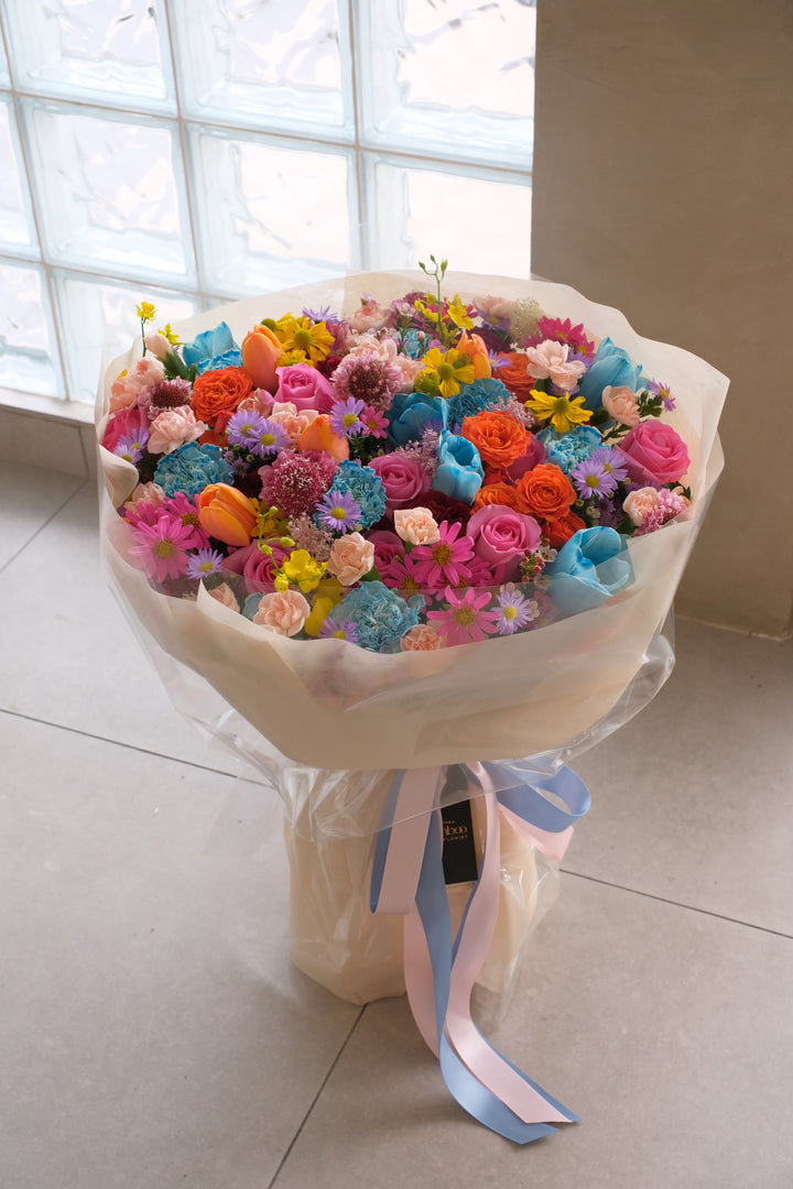Vibrant Omakase bouquet in pink, purple, blue, and orange tones with artistic sculpted wrapping