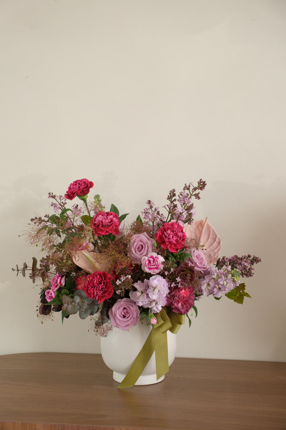 Artistic garden-modern floral centerpiece for Mother's Day 2026, sophisticated purple and pink vase arrangement.