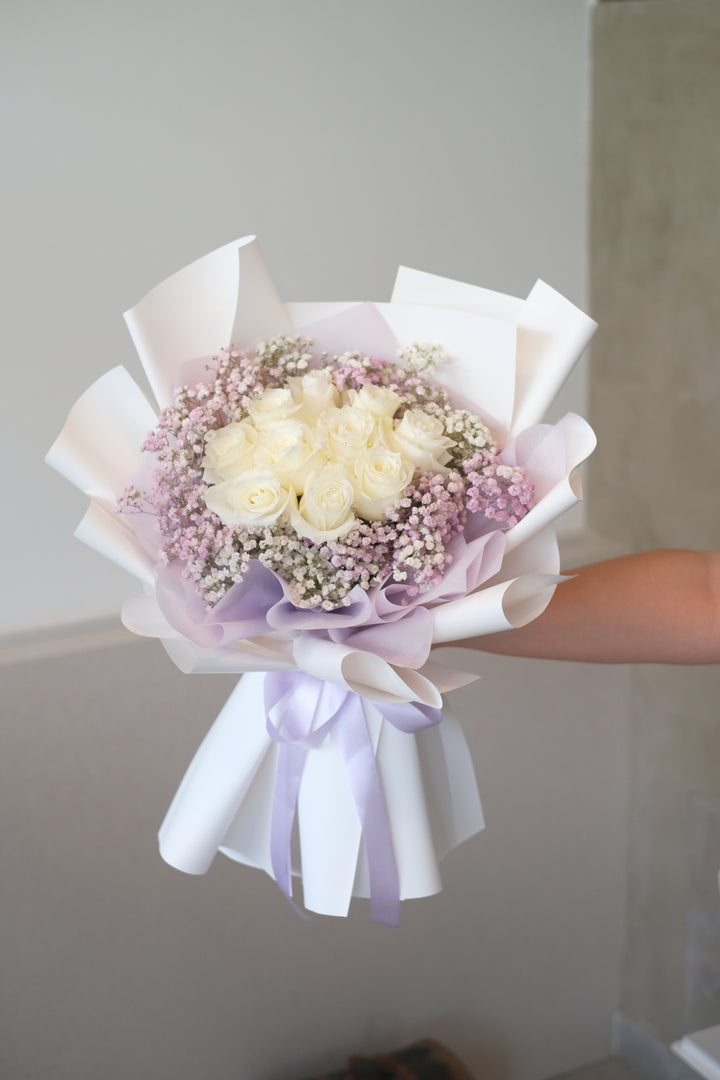 Premium white roses surrounded by angelic lilac baby’s breath, elegantly wrapped in a classic white paper. Timeless floral arrangement, luxury bouquet, Penang florist, romantic flowers.