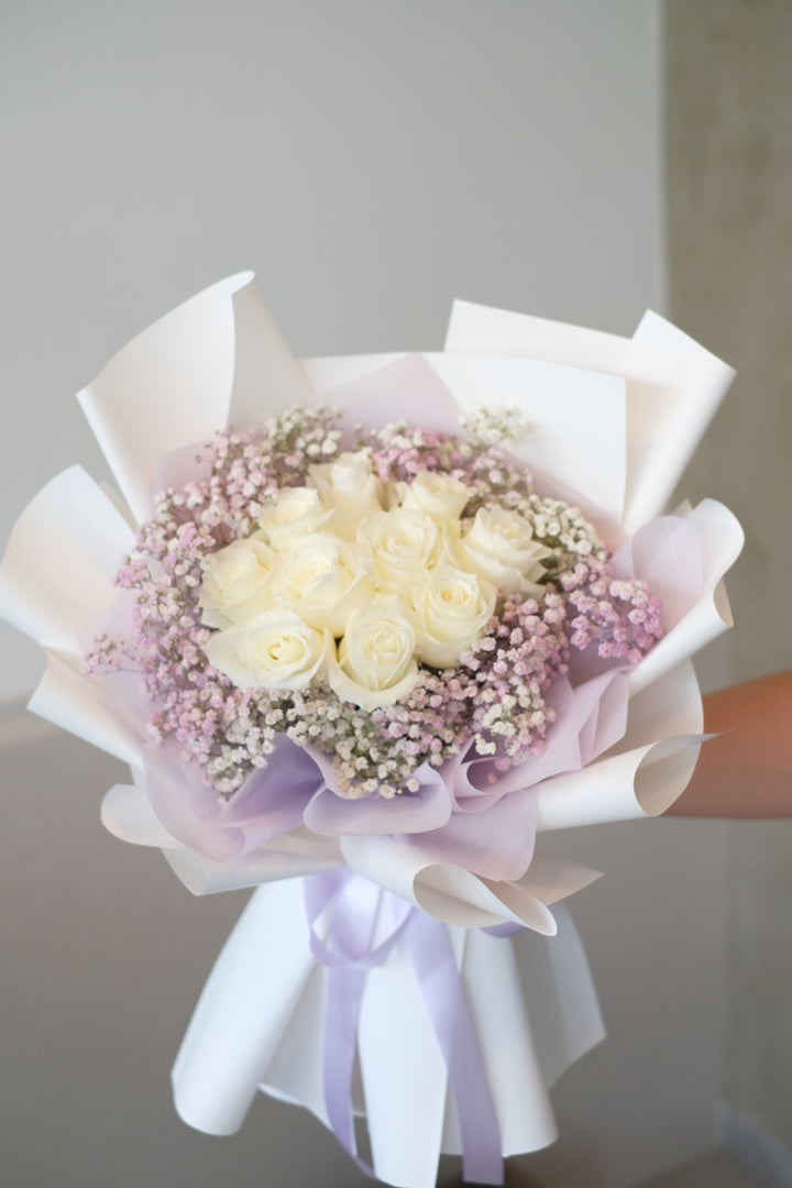 Premium white roses surrounded by angelic lilac baby’s breath, elegantly wrapped in a classic white paper. Timeless floral arrangement, luxury bouquet, Penang florist, romantic flowers.